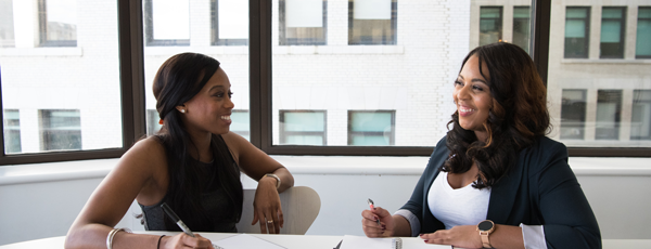 Business women meeting smiling 600x230